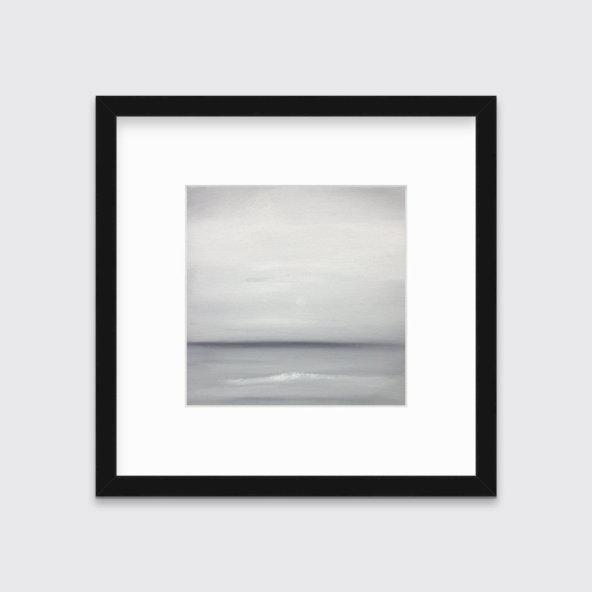 A tonal grey abstract print in a black frame with a mat hangs on a white wall.