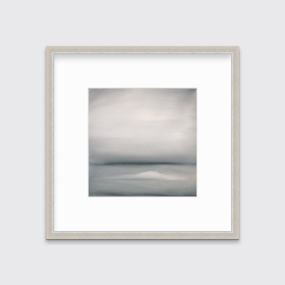A tonal grey abstract print in a silver frame with a mat hangs on a white wall.