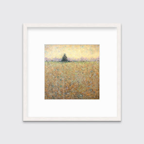 A green, orange and yellow abstract landscape print in a whitewashed frame with a mat hangs on a white wall.