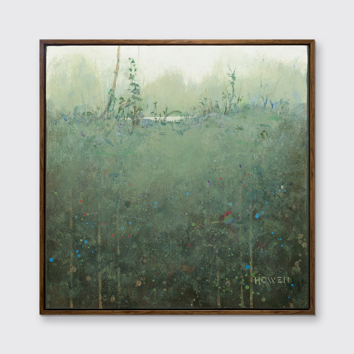 A dark muted green abstract landscape print in an oak wood floater frame hangs on a white wall.