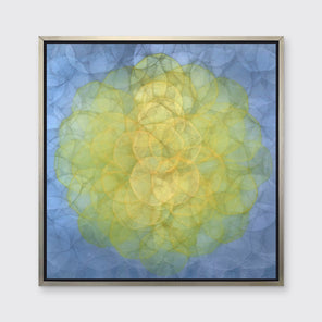 A blue and yellow abstract geometric print in a silver floater frame hangs on a white wall.