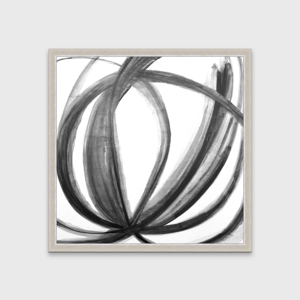 A black, grey and white abstract print in an unmatted silver frame hangs on a white wall.