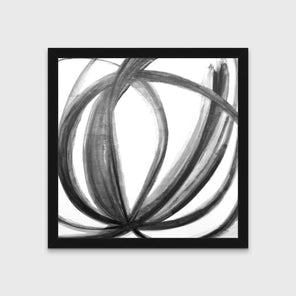 A black, grey and white abstract print in an unmatted black frame hangs on a white wall.