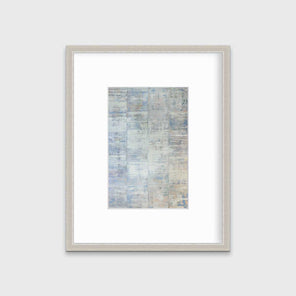 A white and blue abstract print in a silver frame with a mat hangs on a white wall.