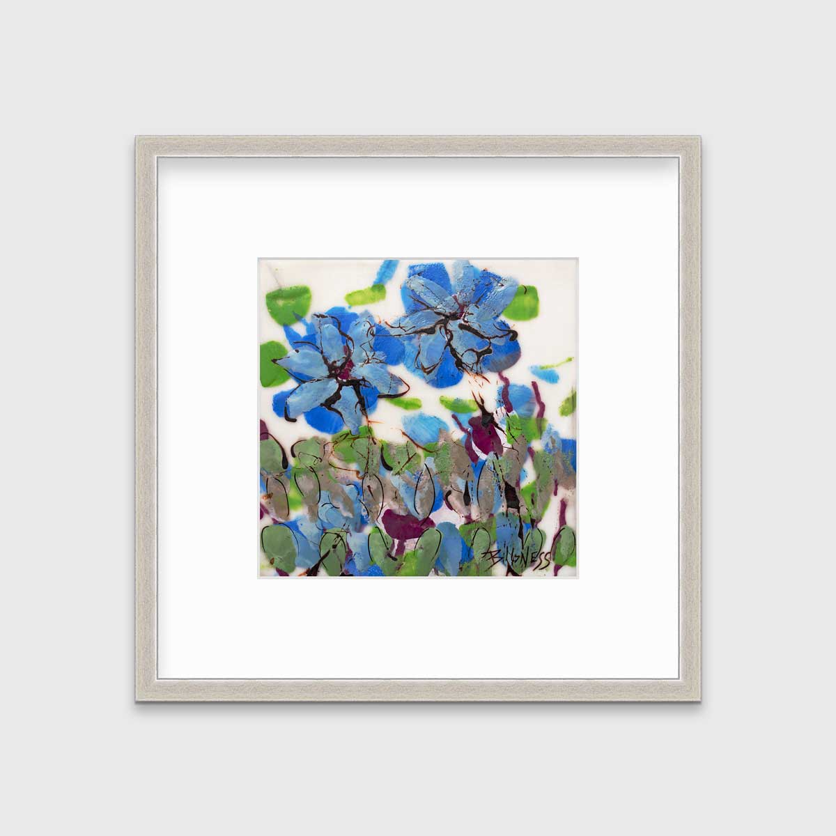 A blue, green and white abstract floral print in a silver frame with a mat hangs on a white wall.
