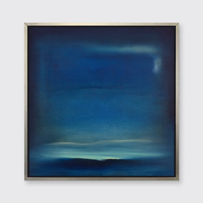 A dark blue and teal with accents of light yellow abstract print in a silver floater frame hangs on a white wall. 