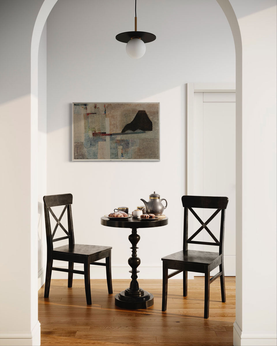 An abstract painting by Stanley Bate hangs on a wall above a dining table with two chairs. In the primary part of the composition a red and grey bar balances a black mountainous form.