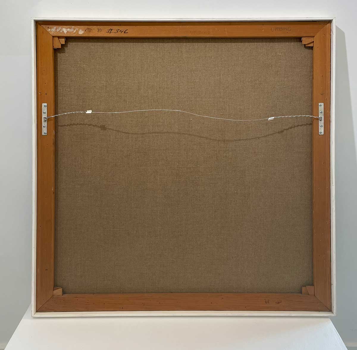The back of the painting with the title and hanging wire.