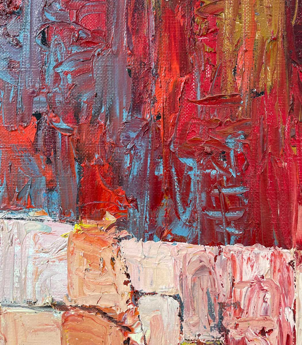 A close up of the texture of red, blue, white and light pink paint.