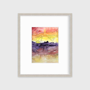 A red, orange, yellow, purple and black abstract landscape print in a silver frame with a mat hangs on a white wall.
