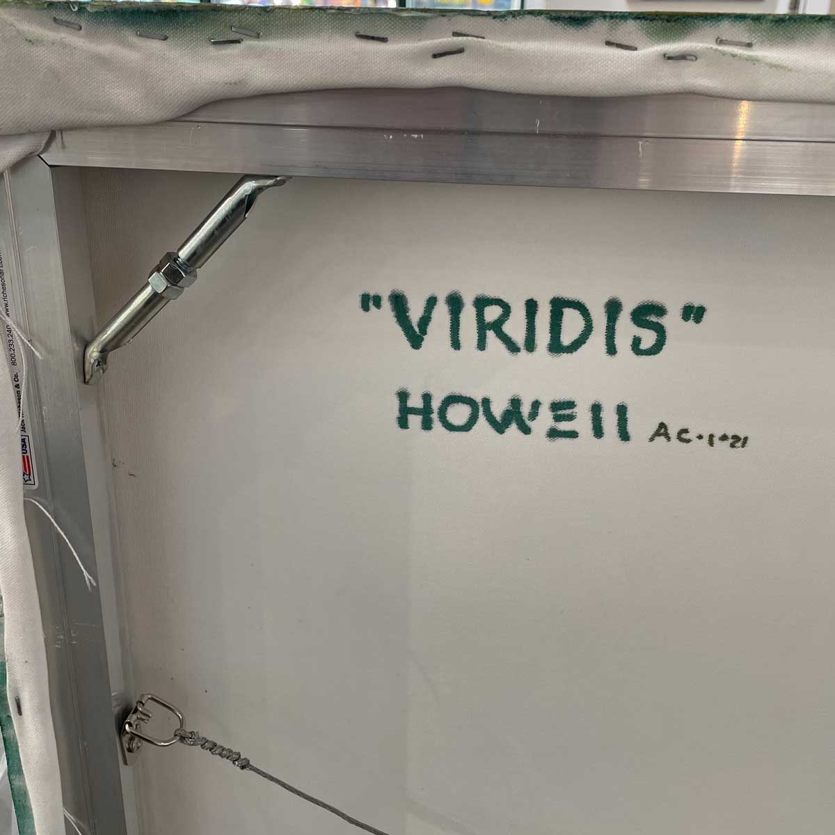 A close up of the back of the painting of the title and the artist's name.