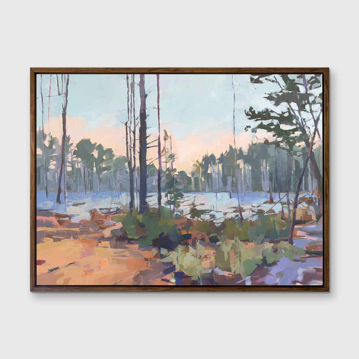 A light blue, green, brown and purple abstract landscape print in an oak wood floater frame hangs on a white wall.