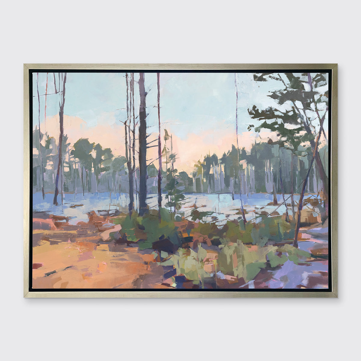 A light blue, green, brown and purple abstract landscape print in a silver floater frame hangs on a white wall.