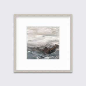 A beige, white, brown and grey abstract print in a silver frame with a mat hangs on a white wall.