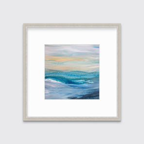 A blue, teal, yellow and white abstract print in a silver frame with a mat hangs on a white wall.