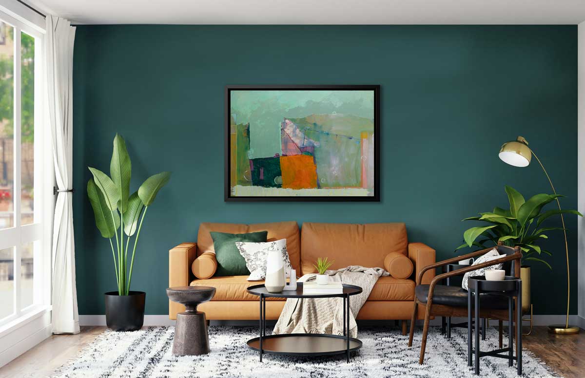 A teal, orange and green abstract print in a black floater frame hangs on a dark teal wall above a dark orange sofa with pillows and a white blanket, a black round coffee table, a dark wood and black chair and two potted floor plants.