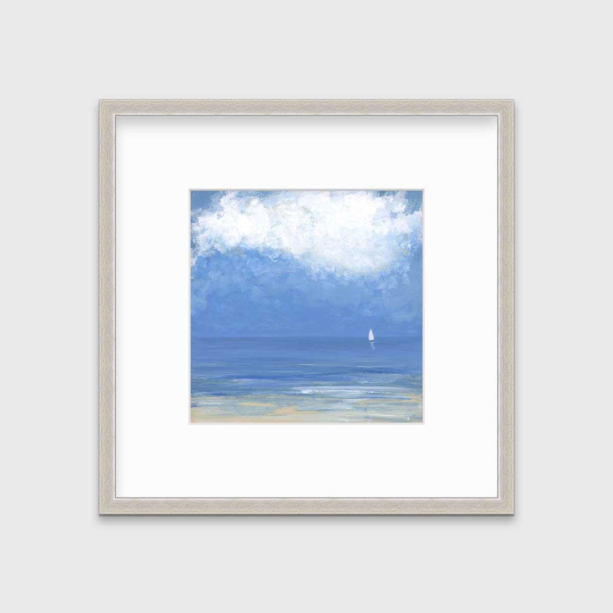 A blue, beige and white abstract seascape print with a small sailboat in a silver frame with a mat hangs on a white wall.