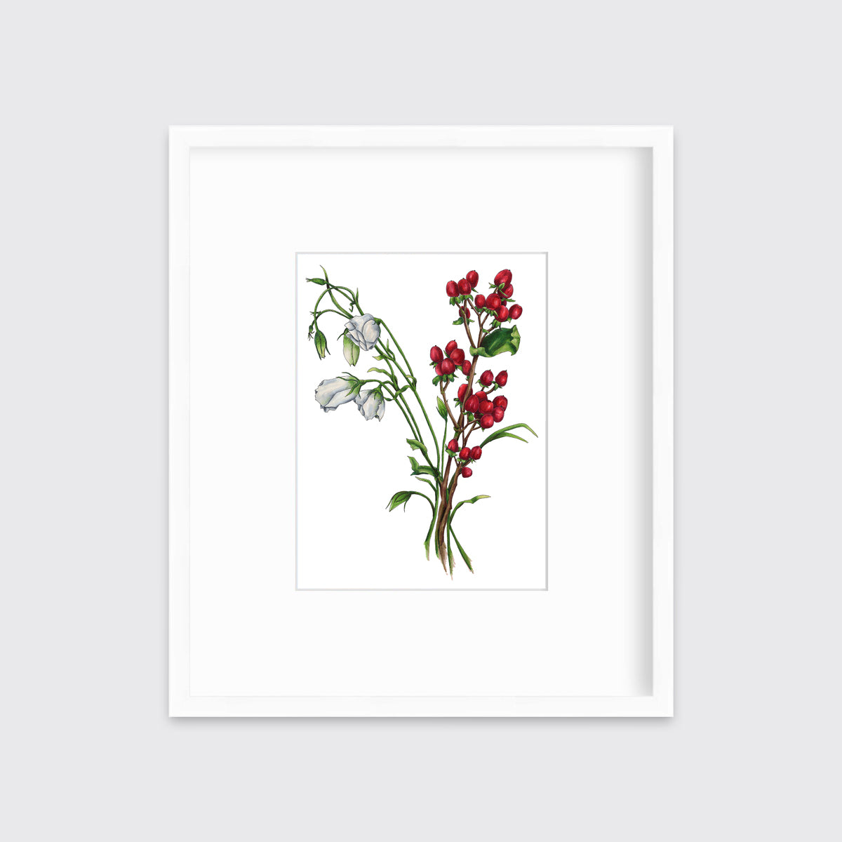 A print of white and red flowers hangs in a white frame on a white frame.