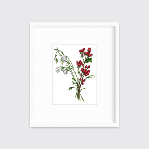 A print of white and red flowers hangs in a white frame on a white frame.