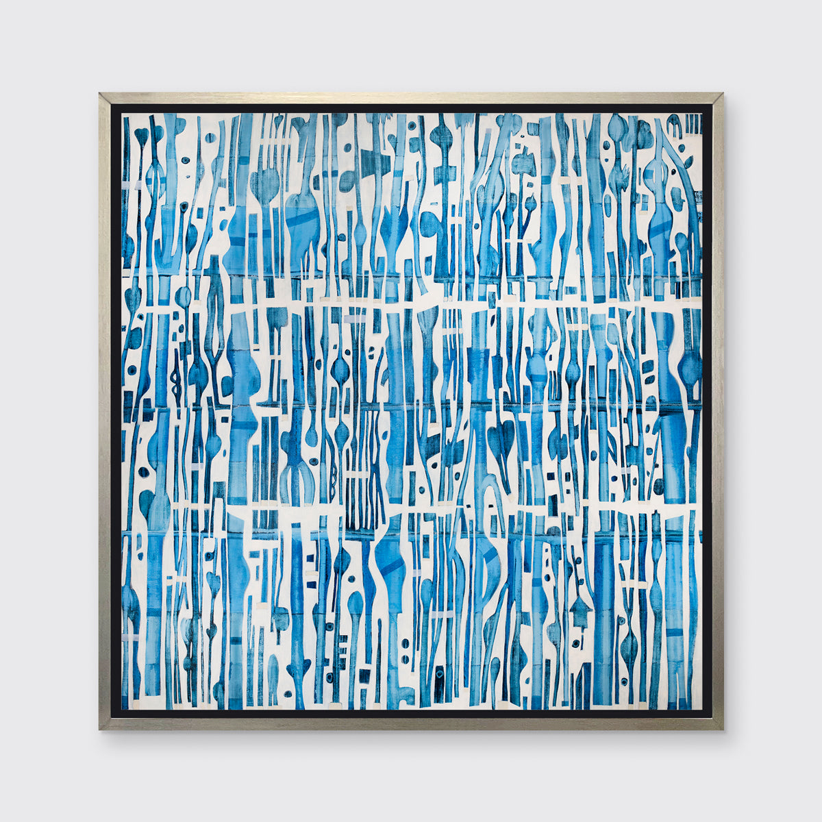 A blue and white abstract print in a silver floater frame hangs on a white wall.