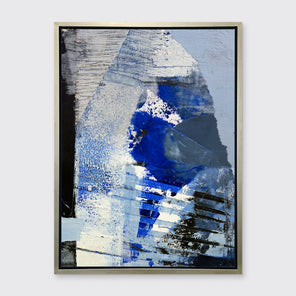A blue, white and black abstract print in a silver floater frame hangs on a white wall.