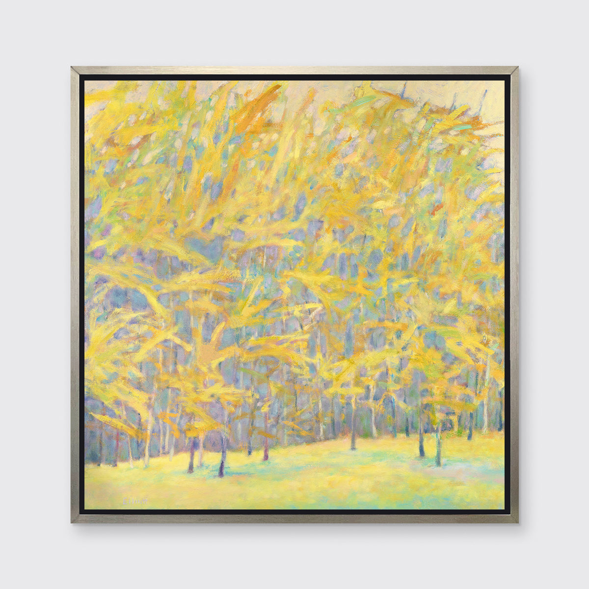 A yellow and blue abstract tree landscape print in a silver floater frame hangs on a white wall.