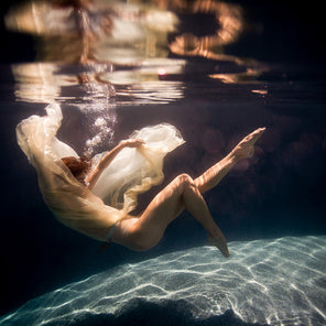 A photograph of a woman surrounded by fabric floating in water by Alyssa Fortin.