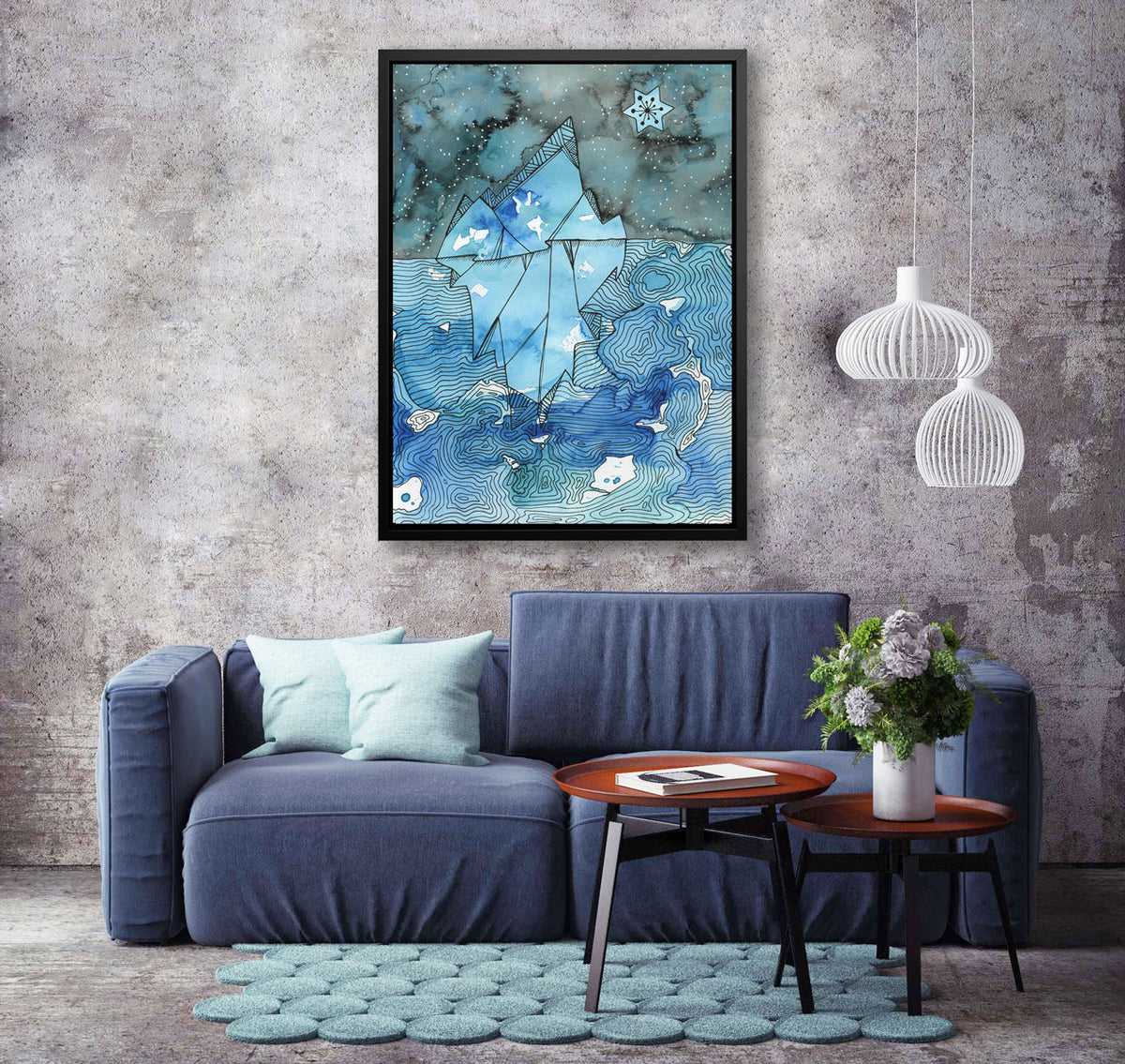 A blue illustration print in a black floater frame hangs on a textured grey wall above a blue sofa and modern, tiered coffee table. 