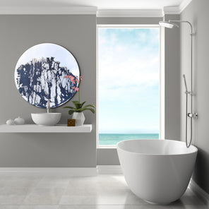 Circular mirror with abstract, mixed media painting covering a majority of the surface. Mirror is mounted on the wall, to the left, in the bathroom above the sink. On the right is a bathtub that overlooks the ocean.   