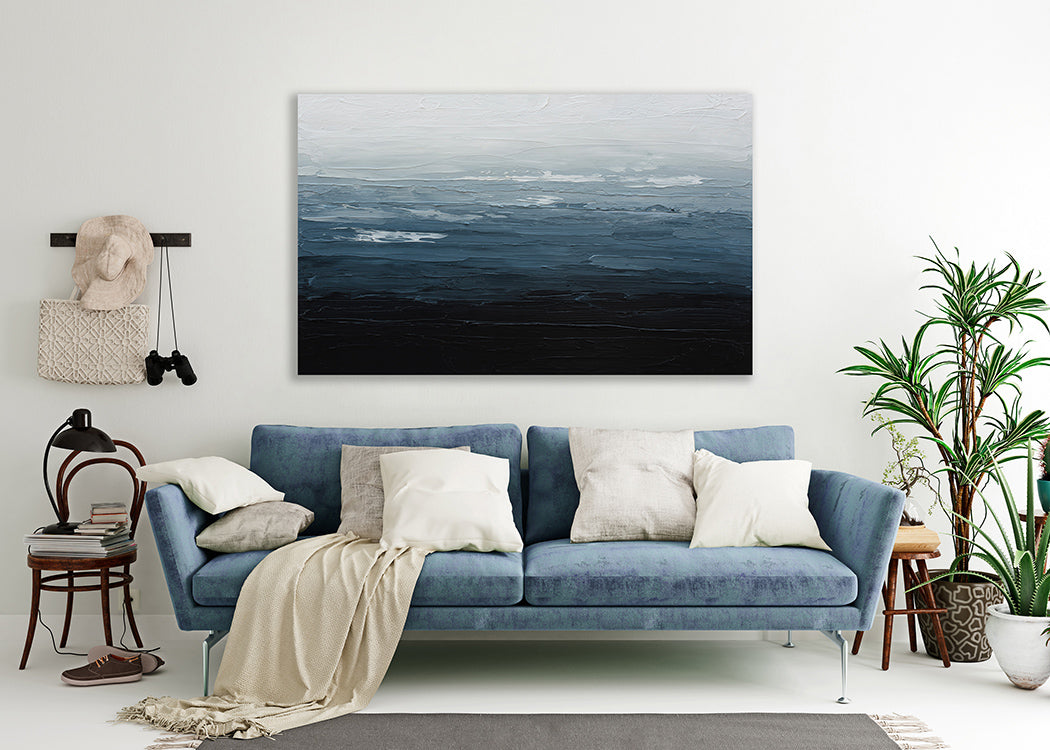 A blue, white and navy textured abstract painting by Teodora Guererra hangs on a white wall above a midcentury velvet blue sofa.