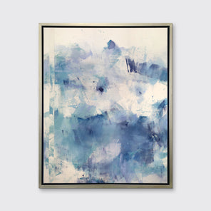 A blue, purple, and off-white abstract canvas print framed in a silver frame hangs on a white wall.