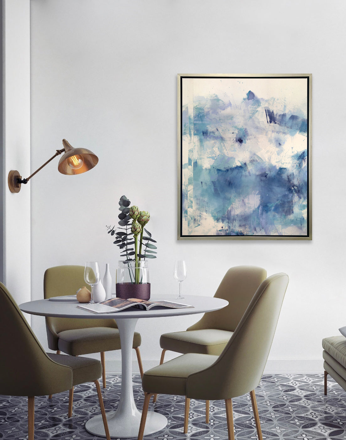 A blue and white abstract print hangs on a wall above a modern dining room table with four olive-green chairs. 