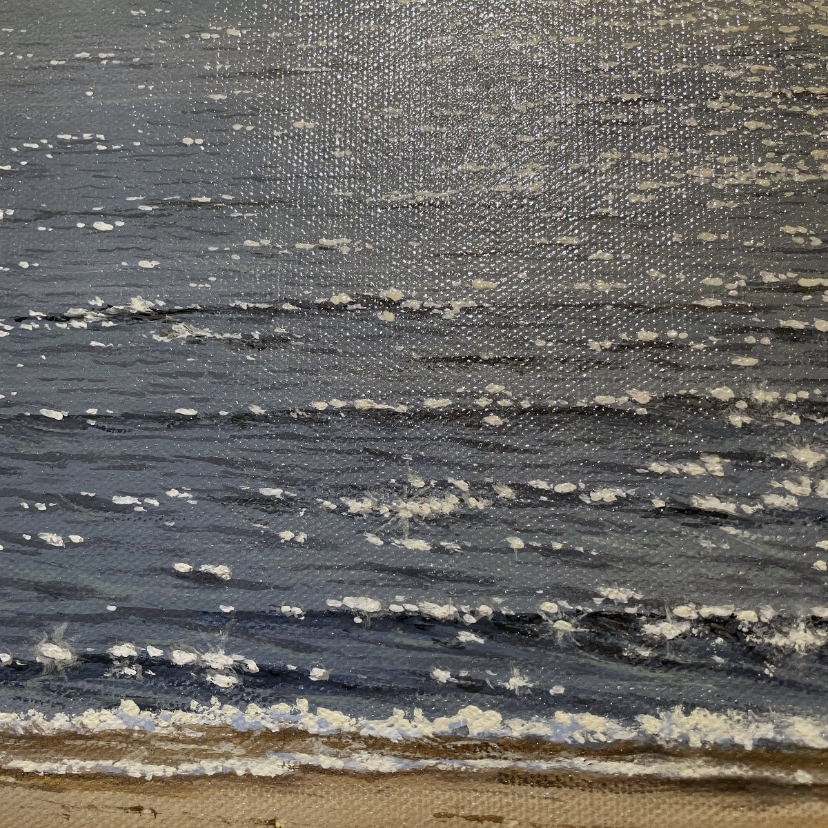 A up close detail of the blue water with small patches of white to represent sunlight.