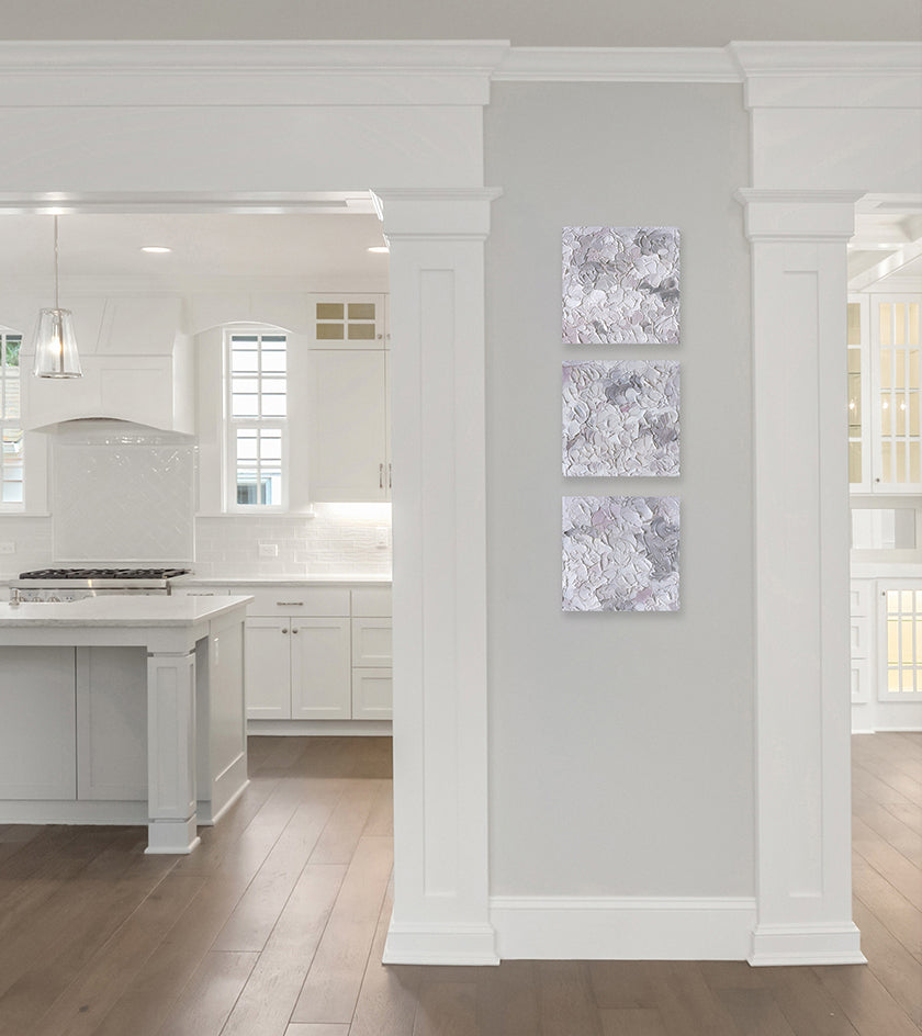 Three abstract painting by Teodora Guererra hang on a kitchen wall.