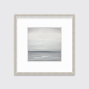 A tonal grey abstract print in a silver frame with a mat hangs on a white wall.